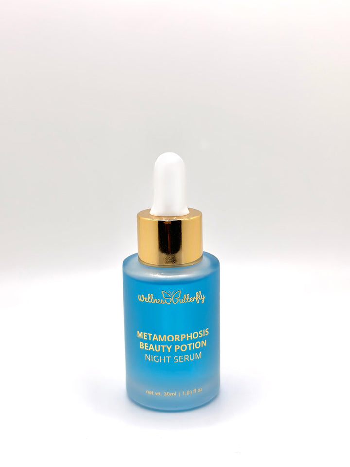 Wellness Butterfly Skincare Matamorphosis Night Serum 1.01oz. White background. Clear glass bottle, with gold lettering. Light blue serum. White, gold dropper. At Ippodaro Salon, TX